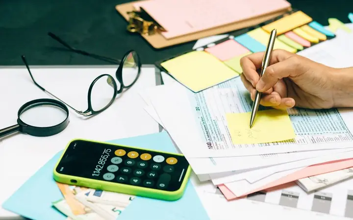 Tax forms, calculator and notes on a desk